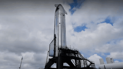 Large Rocket On Top Of Building With Clouds GIF