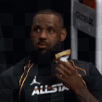 Lebron James Is Sitting In A Locker Room Eating A Snack . GIF