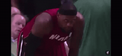 Lebron James Is Wearing A Headband And A Miami Jersey While Sitting On The Bench . GIF