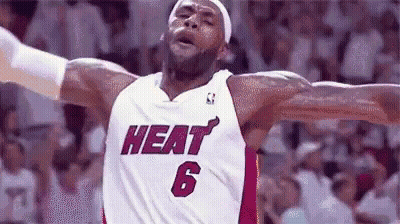 Lebron James Is Wearing A Heat Jersey With His Arms Outstretched During A Game . GIF