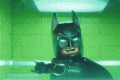 Lego Batman Standing In Front Of Green Brick Wall GIF