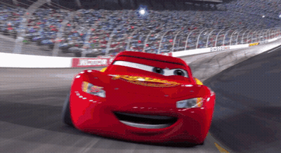 Lightning Mcqueen From The Movie Cars Is Smiling While Driving On A Race Track GIF