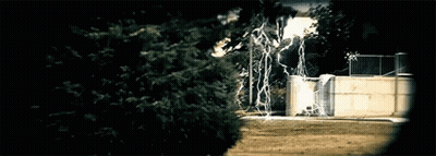 Lightning Strikes Behind Fence And Trees GIF