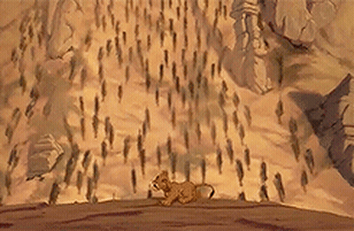 Lion Cub Walking Across Desert With Crowd GIF