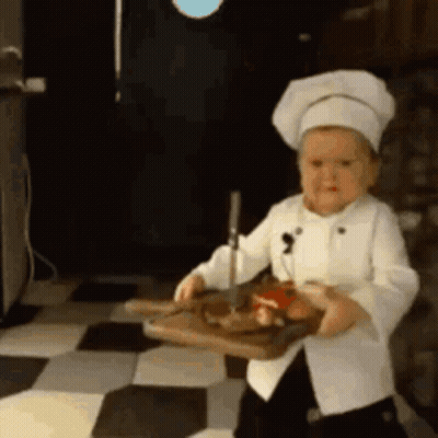 Little Boy Chef Holding Cutting Board With Meat GIF