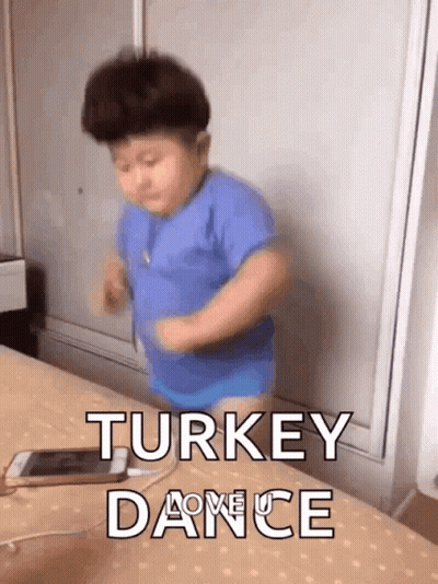 Little Boy In Blue Shirt Dancing On Bed Next To Phone GIF