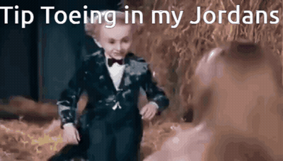 Little Boy In Tuxedo And Bow Tie Dancing In Field GIF