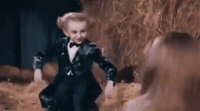Little Boy In Tuxedo Dancing With Woman In Field GIF