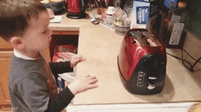 Little Boy Playing With Toaster Showing 6:00 GIF