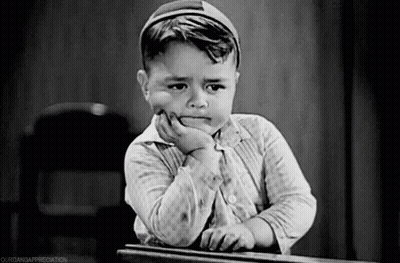 Little Boy Sitting At Desk With Hand On Chin Sad GIF