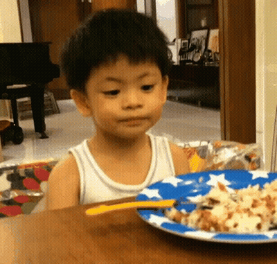 Little Boy Sitting At Table With Plate Of Food GIF