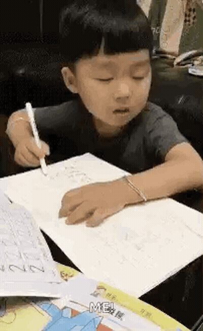 Little Boy Sitting At Table Writing GIF