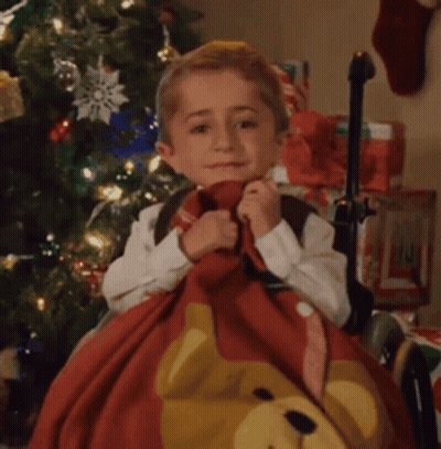 Little Boy Sitting By Christmas Tree Holding Teddy Bear Blanket GIF