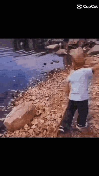Little Boy Standing on Rock Near Water