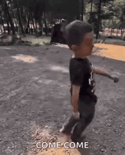 Little Boy Walking Down Dirt Road Holding Stick GIF