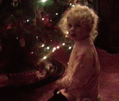Little Girl Covering Face By Christmas Tree GIF