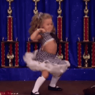 Little Girl Dancing With Trophies On Stage GIF