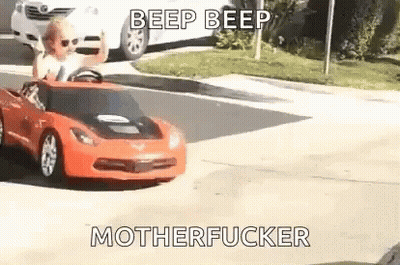 Little Girl Driving Red Toy Car Down Street GIF