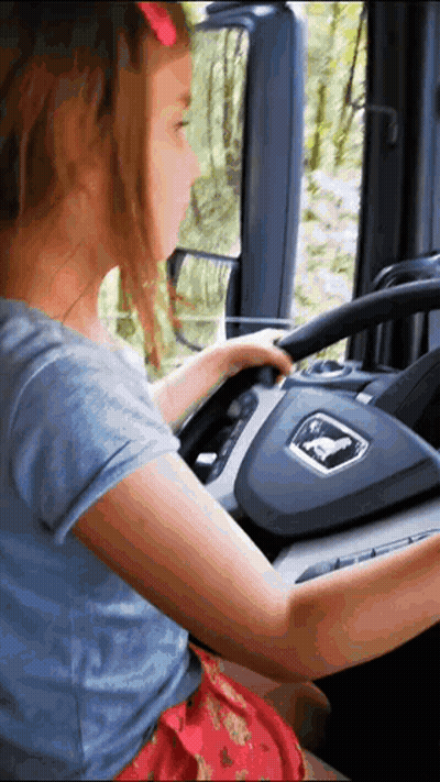 Little Girl Driving Truck With Man Logo GIF