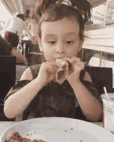 Little Girl Eating Pizza At Table GIF