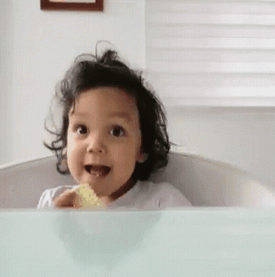 Little Girl In Bathtub With Sponge In Mouth GIF