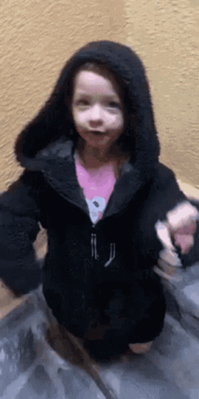 Little Girl In Black Jacket On Staircase GIF