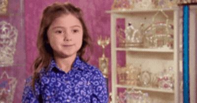 Little Girl In Blue Shirt With Crowns And Tiaras GIF