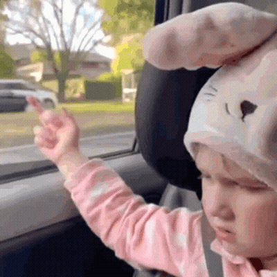 Little Girl In Bunny Hat Giving Middle Finger In Car GIF