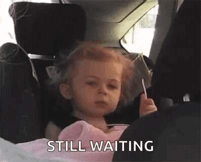Little Girl In Car Seat Holding Lollipop GIF