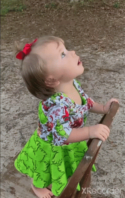 Little Girl In Green Dress Looking Up At Sky GIF