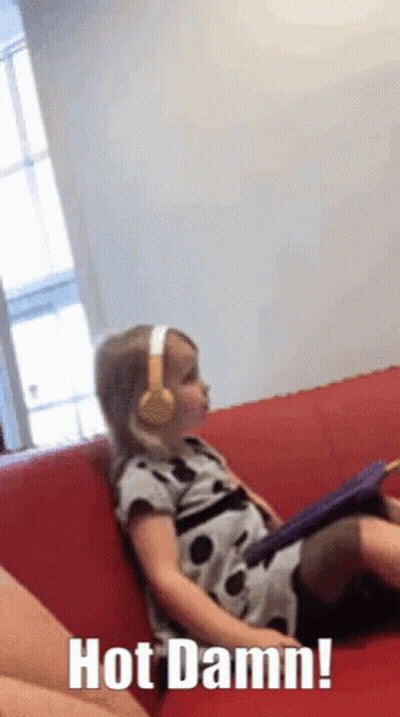 Little Girl In Headphones On Red Couch Saying Hot Damn GIF