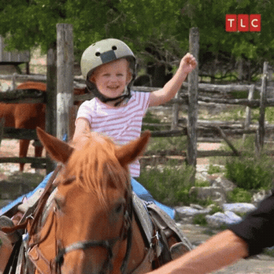 Little Girl In Helmet Riding Brown Horse GIF