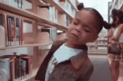 Little Girl In Library At Bookshelf GIF