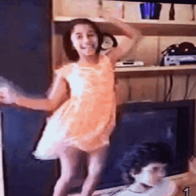 Little Girl In Pink Dress Dancing In Front Of TV GIF
