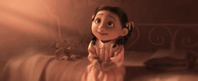 Little Girl In Pink Dress Sitting On Bed Looking Up GIF