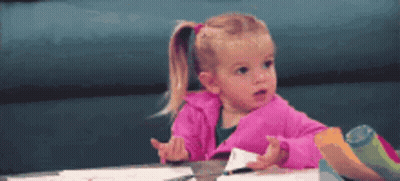 Little Girl In Pink Jacket At Table GIF