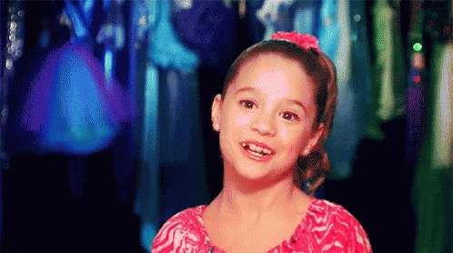 Little Girl In Pink Shirt Smiling In Front Of Closet GIF