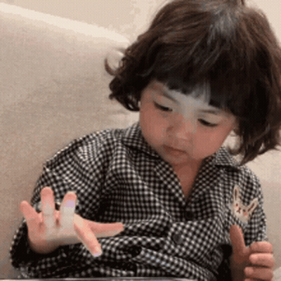 Little Girl In Plaid Shirt Playing With Tablet GIF