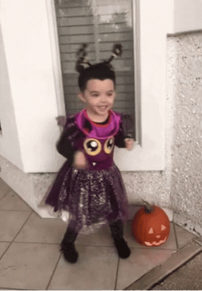 Little Girl In Purple Costume Next To Pumpkin GIF