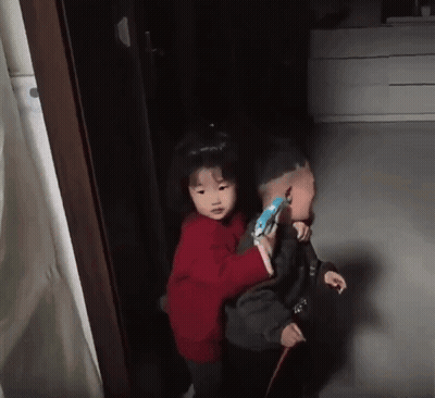 Little Girl In Red Sweater Carrying Boy GIF