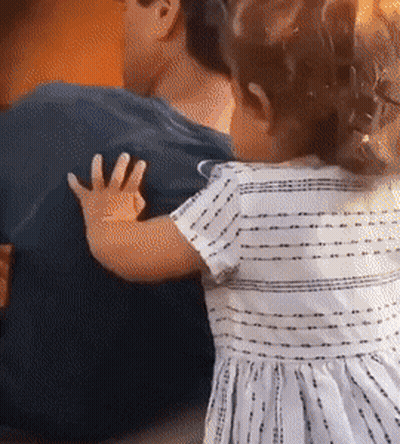 Little Girl In Striped Dress Hugging Man's Back GIF