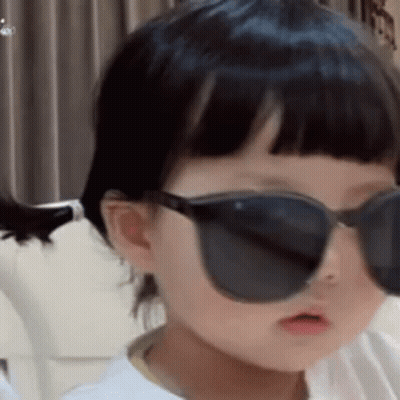 Little Girl in Sunglasses Sitting on Couch