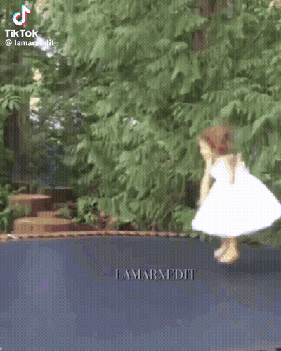 Little Girl In White Dress Jumping On Trampoline GIF