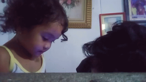 Little Girl In Yellow Tank Top Looking At Picture GIF