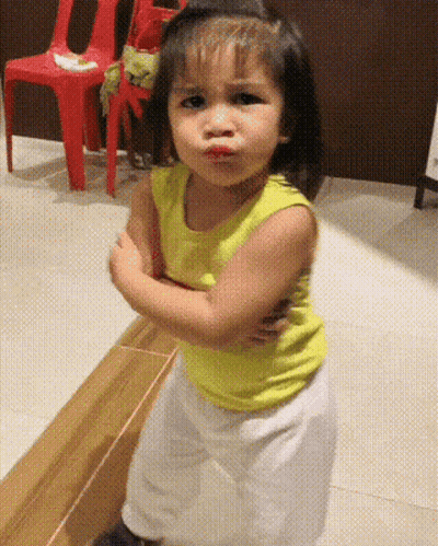 Little Girl In Yellow Tank Top Making A Face GIF