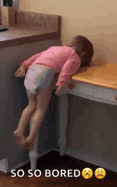 Little Girl Laying On Table Saying So So Bored GIF