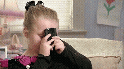 Little Girl Looking Through Cell Phone GIF