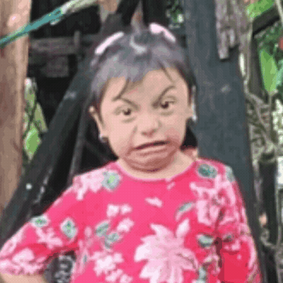 Little Girl Making Funny Face In Front Of Tree GIF