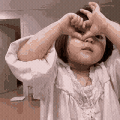 Little Girl Making Heart With Hands Over Eyes GIF