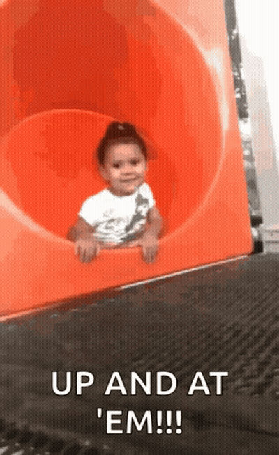 Little Girl Riding Down Orange Slide Saying Up And At Em GIF